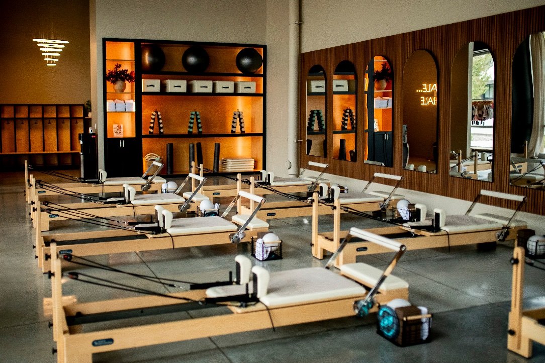 Rows of Reformers inside PureForm’s warm, wood-accented Sioux City studio