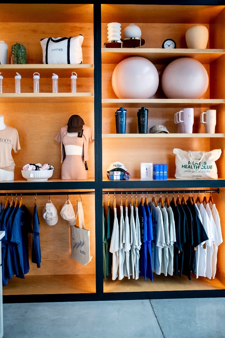 Shelves of PureForm apparel and wellness goods inside the studio